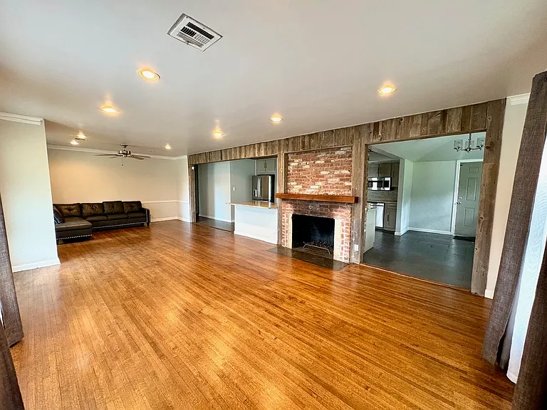 Living room with gas fireplace, connected to open-concept kitchen. Great for hosting.