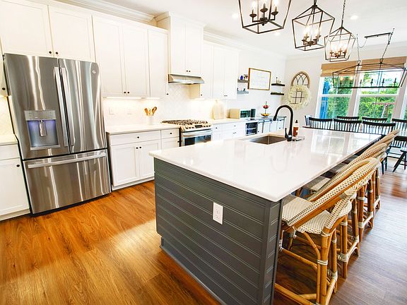 Inside, you'll find a bright, open floor plan that's made for real life. The gourmet kitchen is the heart of this home, featuring an oversized quartz island and adjacent dining room for gatherings, with line of sight into the family room and backyard.