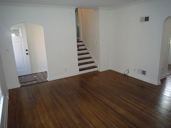 Living room, stairs to bedrooms, archway to dining room, front door to the left