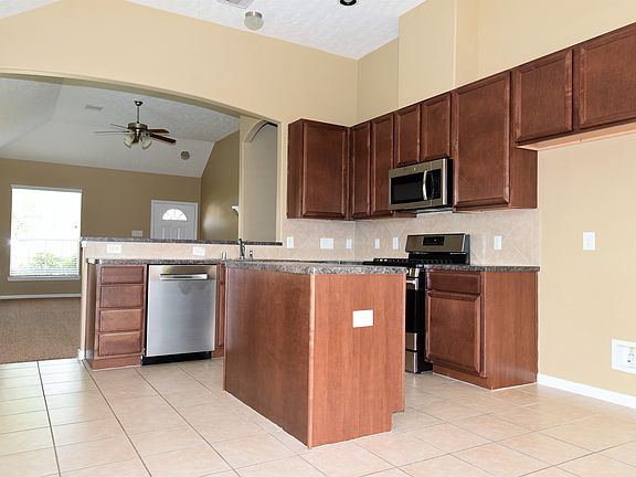 Kitchen with center island, upgraded cabinets and tile.