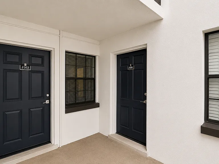 Modern apartment entryway with elegant dark doors and stylish windows, offering a welcoming and sophisticated ambiance.