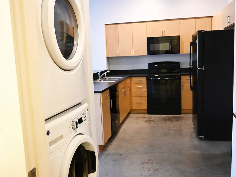 In-unit washer and dryer next to a kitchen at The Sawyer.