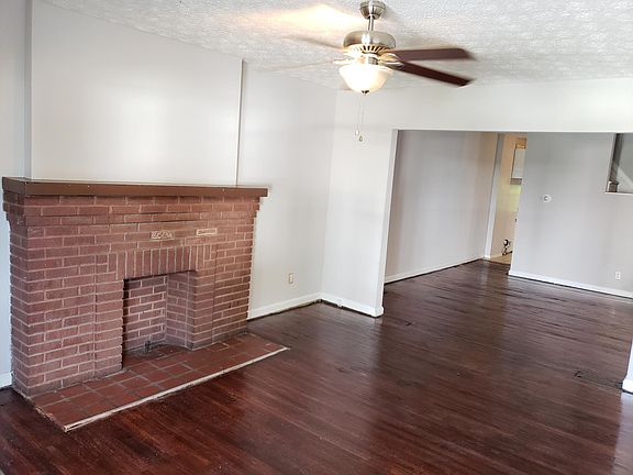 Living room with brick fireplace and ceiling fan