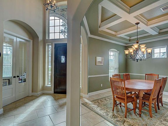 NOTICE THE TILE FLOORING AND STAINED WOOD FRONT DOOR