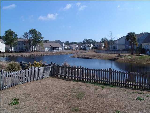home has fence and is on a pond