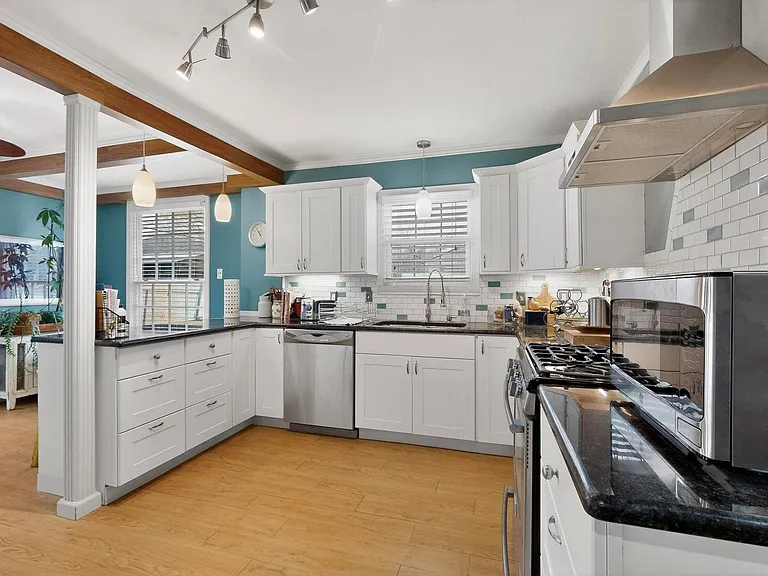 A stylish kitchen with a window and white cabinets, creating a bright and inviting atmosphere.