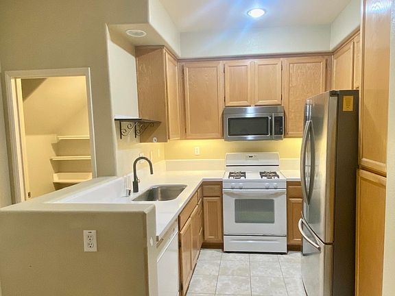 Kitchen with new countertops, sink, refrigerator and gas cooktop
