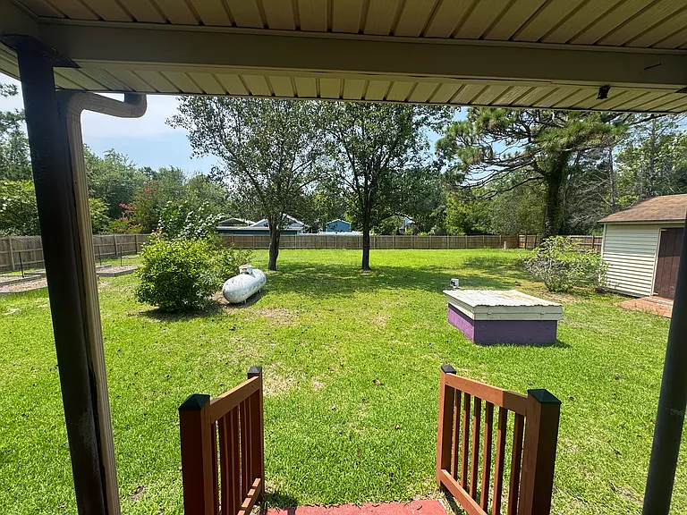 Backyard: Spacious fenced backyard with on-site propane tank and storage shed.
