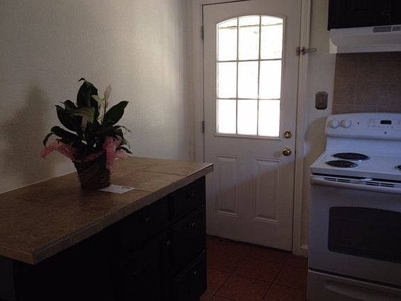 Extra counter space and storage in this darling kitchen - door to the backyard - don't forget the yard is fenced and there is a utility room in the garage - with a washer and dryer!