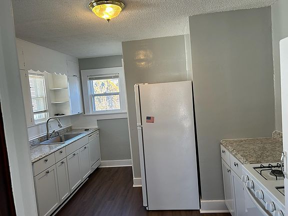 Walking into the kitchen from the living room. Small space to the left for a small table. New kitchen flooring.