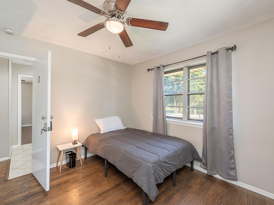 Room equipped with a full sized bed, dresser, closet, trash can, night stand and night light. Front of the house bedroom.