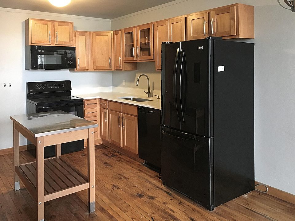 Kitchen with ample cabinet space, new white quartz counters and fridge with ice maker.