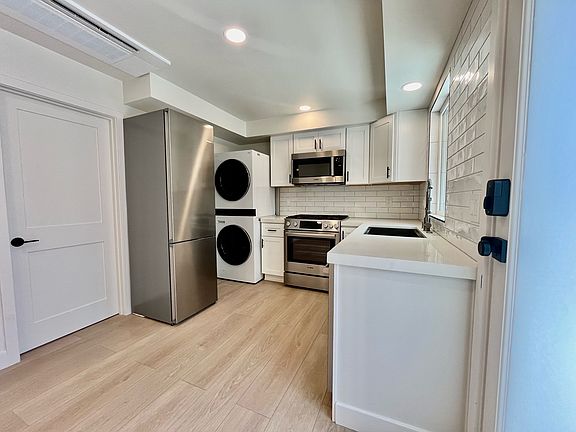Full sized fridge/freezer, stackable washer/dryer, microwave, 5 burner stove/oven, dishwasher, and farmhouse sink with garbage disposal and pull down faucet.