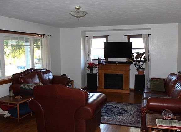 Living room with new front window and beautiful hardwood floors.  Electric fireplace stays with the house.