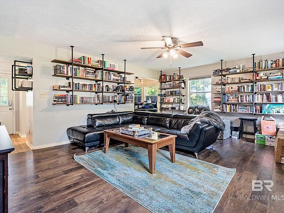 Living room featuring a textured ceiling, a healthy amount of sunlight, and dark hardwood / wood-style flooring