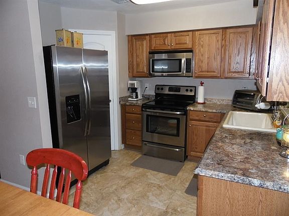 View of kitchen with nice stainless steel appliances and walk in pantry.