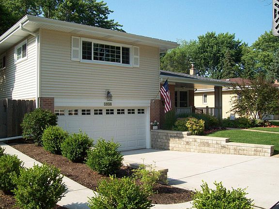 Front of House with new gargae door and retaining wall