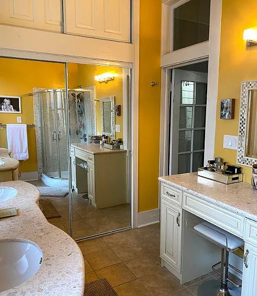 Large closet with mirrors and storage above in master bathroom.