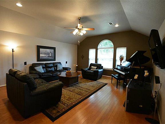 WOOD LAMINATE FLOORS, SPECIALTY CEILING AND A WALL OF WINDOWS MAKE THIS LIVING ROOM INVITING...