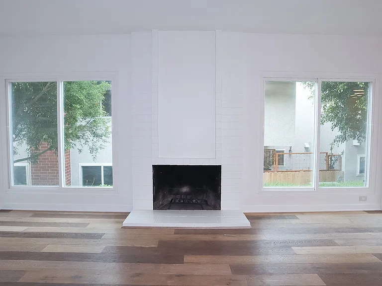 Living Room with hardwood floors and wood-burning fireplace.