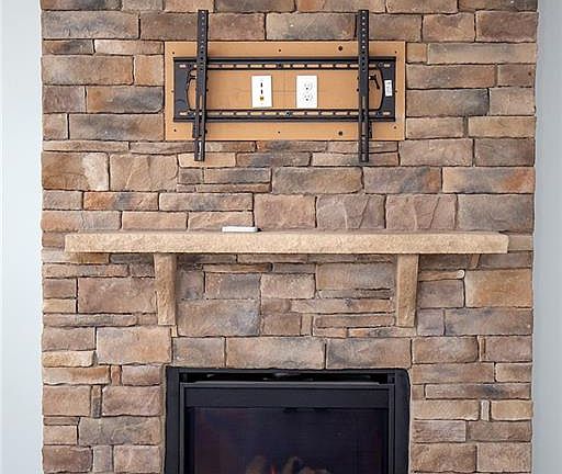 Gas Fireplace with stone surround and mantle and TV mount.