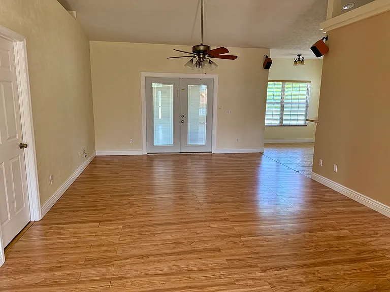 Living room with French doors opening up to fenced backyard.