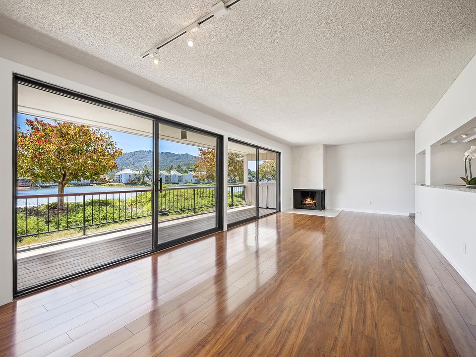 Living room w/ fireplace and large sliders to deck and access gate to community dock.
