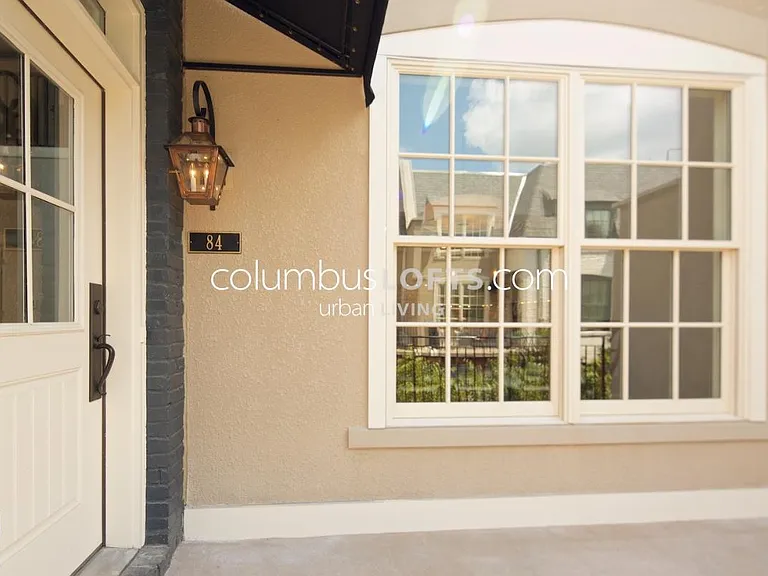 Exterior front porch / patio of unit main entry door and double window into unit dining room