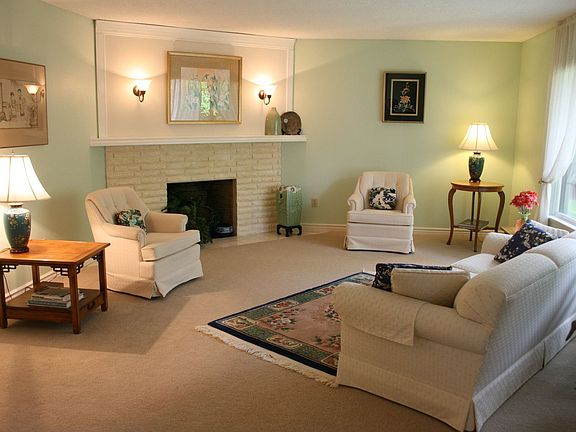 Be "Comfy-cosy" by the fireplace in this living room