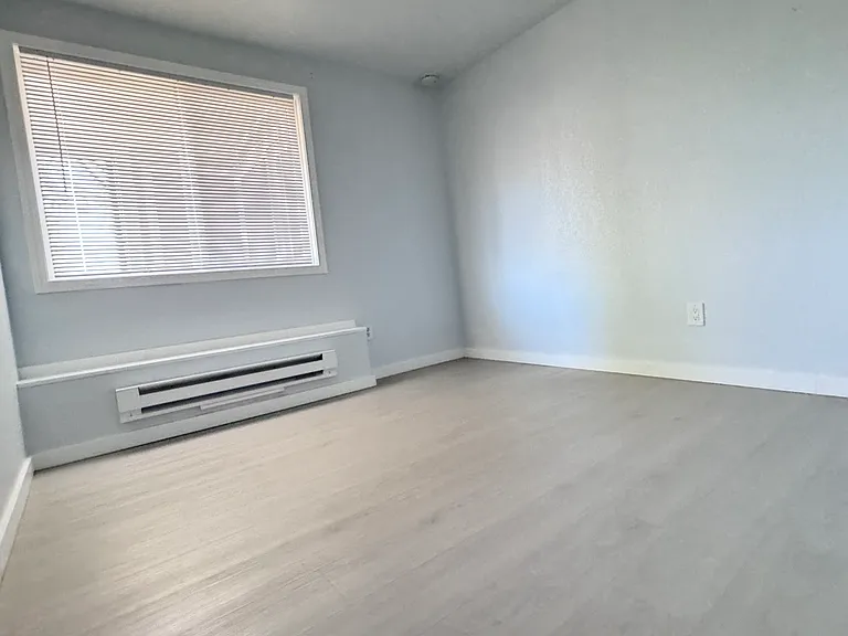 Guest bedroom with closet and window view of patio