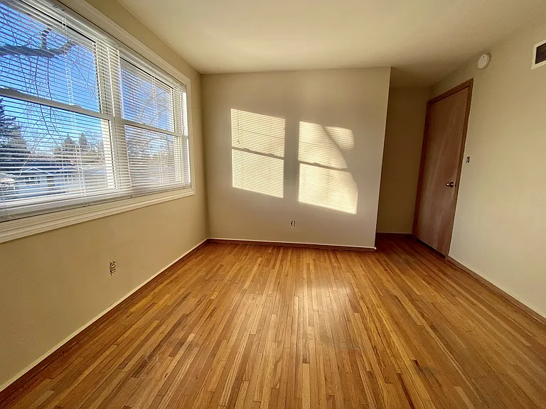 Bright room with large windows, wooden floors, and a serene atmosphere perfect for a cozy bedroom setup. Bright room with large windows, wooden floors, and a serene atmosphere perfect for a cozy bedroom setup.