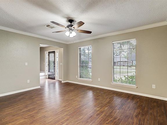 The formal living room is at the front of the house, complete with wood flooring and crown moulding.