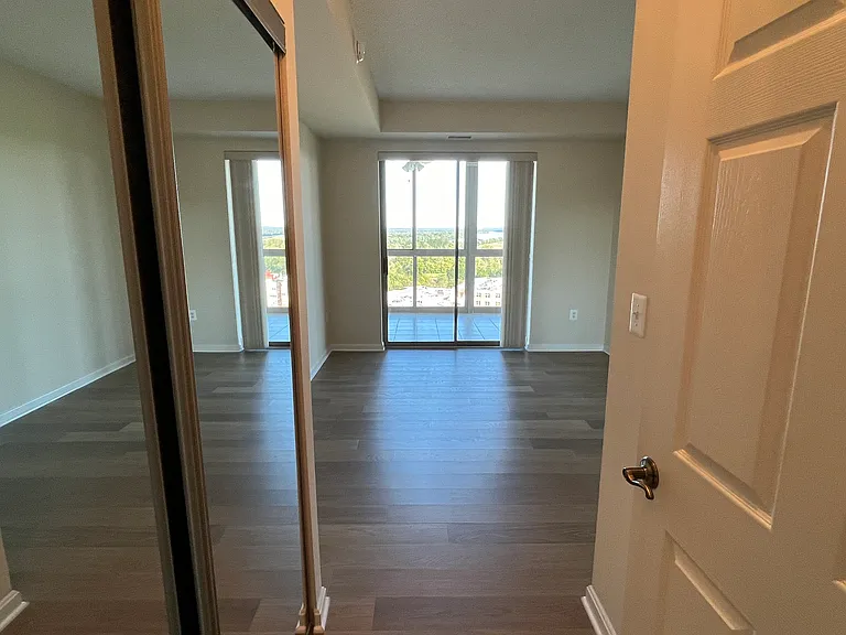 Bedroom #2 with sliding glass door to balcony and mirrored reach-in closet on left