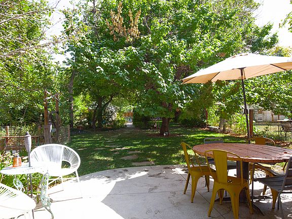 Back patio with pergola, hammock, fireplace, grill, and dining table, large FENCED IN YARD and GARDEN