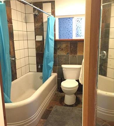 Bathroom with large cast iron tub and wall heater.