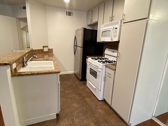 Kitchen with granite countertops and Stove, dishwasher, microwave and refrigerator.