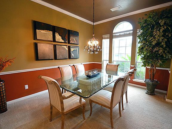 The formal dining room is very warm and rich with two tone accents, high ceilings and tons for sophi