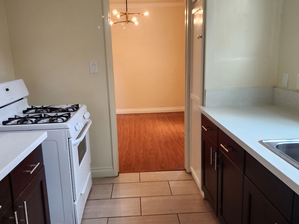 Kitchen, with formal dining room visible past stove. Tall storage closet opposite stove.