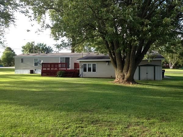 Back of house with patio and small storage shed