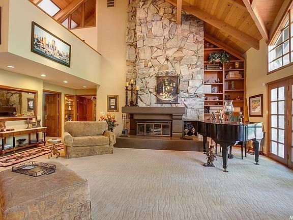 French doors lead to a lovely deck off the living room.  The loft is visible at the left of this photo.  The raised hearth offers additional seating.