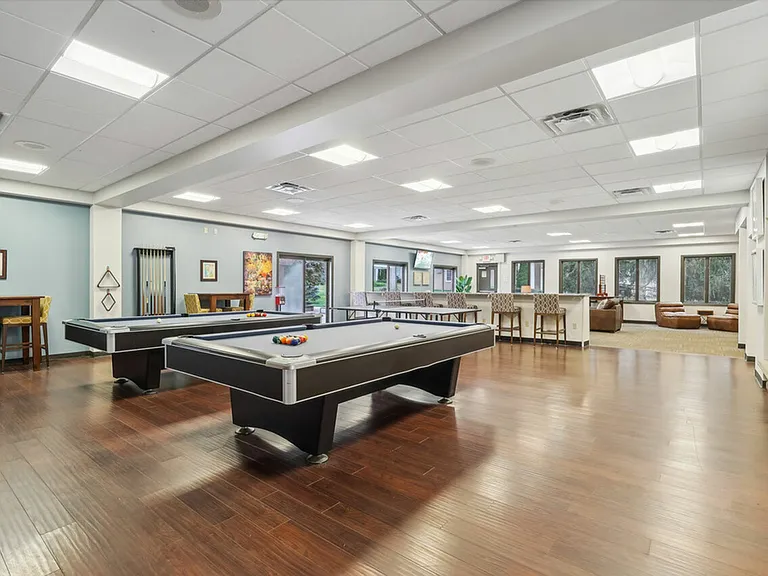 Enjoy the vibrant game room with pool tables and seating at University Oaks Apartments near Kent State University.