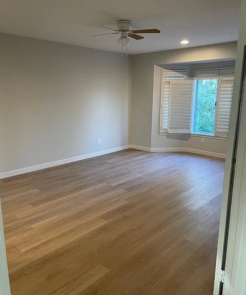 Large primary bedroom with ceiling fan and recessed lights