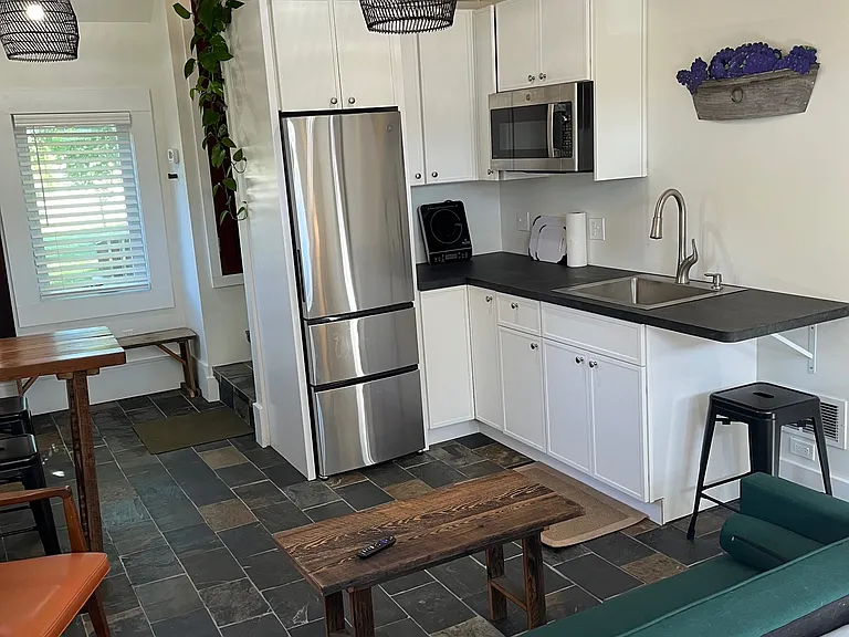The kitchen has a refrigerator, cooktop, and convection/air fryer/microwave.