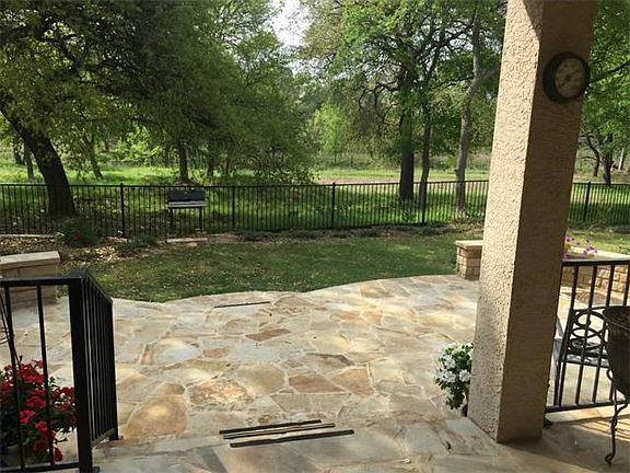 Covered Porch and flagstone patio with seating ledges. Fence