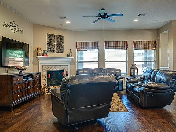 The living room features a fireplace with upgraded design. The wall of windows allows natural light to infiltrate the room.