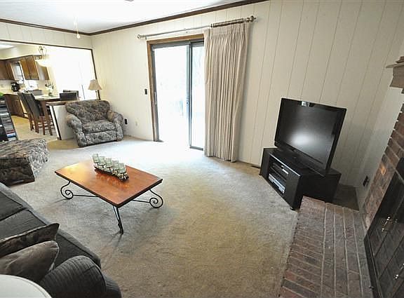 Family room boasts brick fireplace and patio doors to deck.