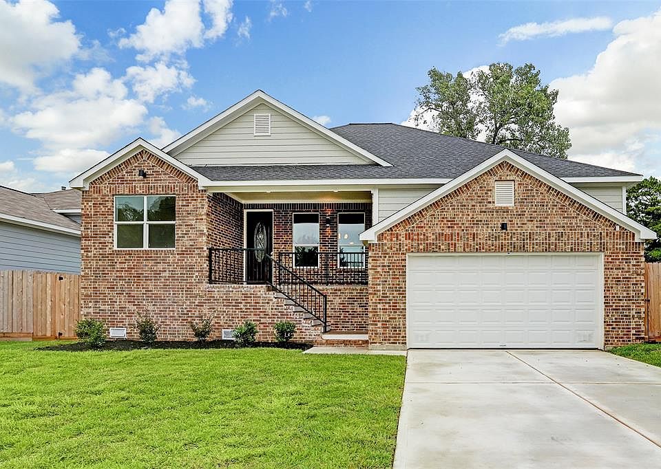 View of this lovely bricked brand new house showing the porch and 2 car garage