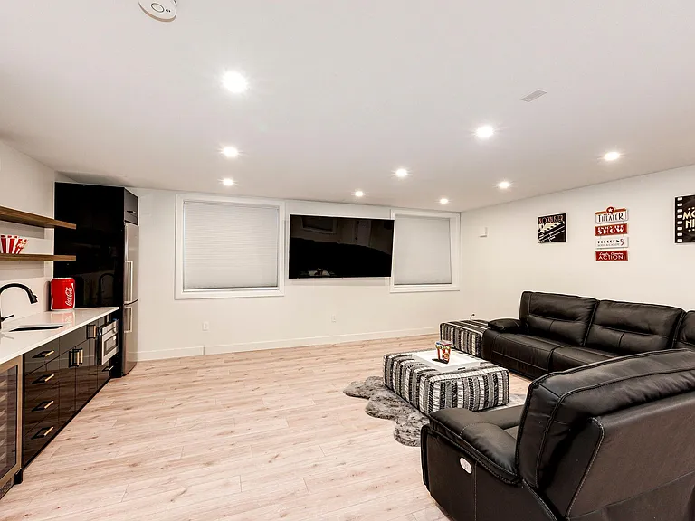 Large size theater room with 85 inch Smart TV. Refrigerator, Microwave, and Drink Chiller.