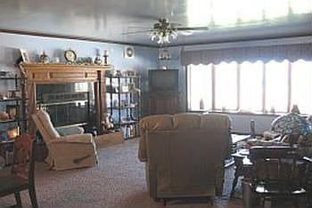 A view into the livingroom area of Great Room with fireplace & huge bow window