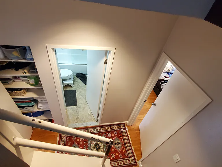 Stairs to the lower level where the bathroom and two bedrooms are located